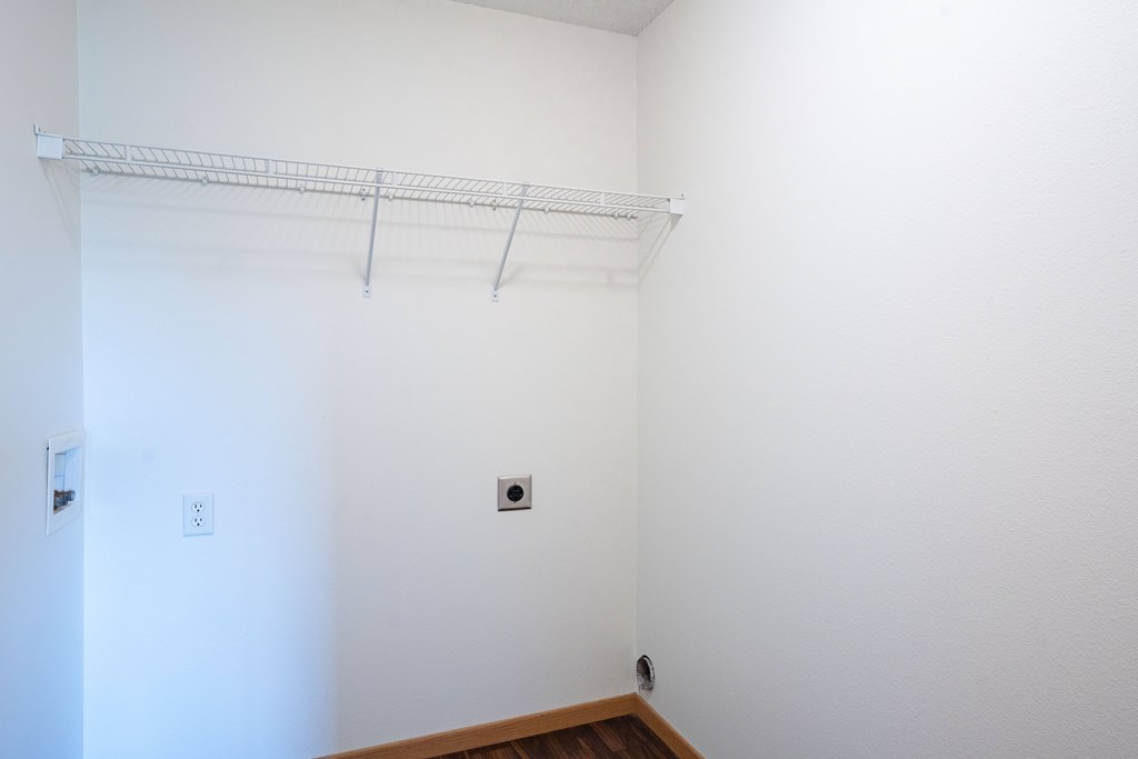 A white wall with a shelf and two electrical outlets. Bismarck, ND Sierra Ridge Apartments