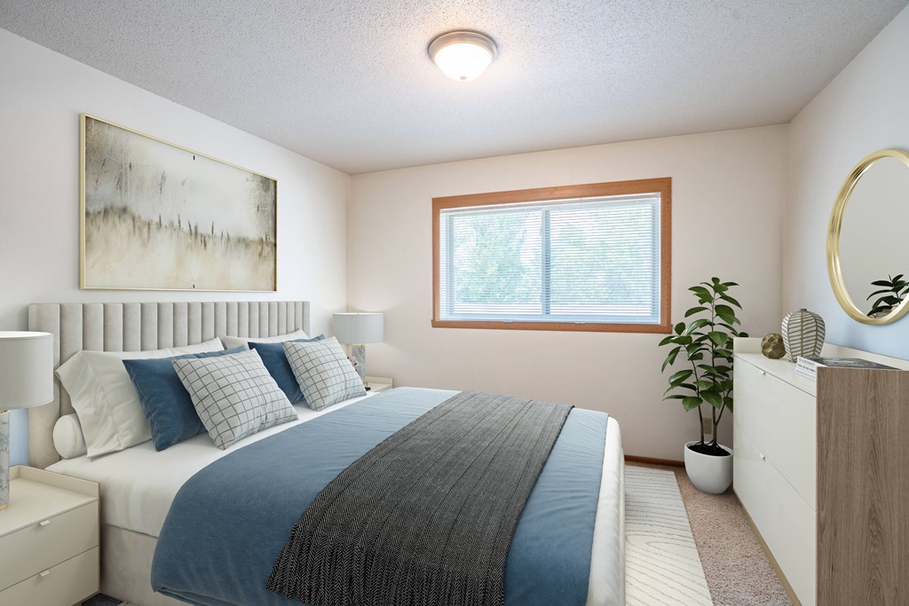 A bedroom with a bed, nightstand, and a painting on the wall. Fargo, ND West Oak Apartments
