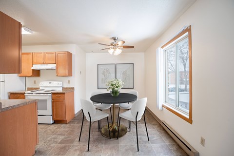 A kitchen with a table and chairs in the middle of the room.