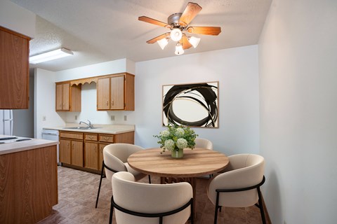 A dining room with a round table and chairs.