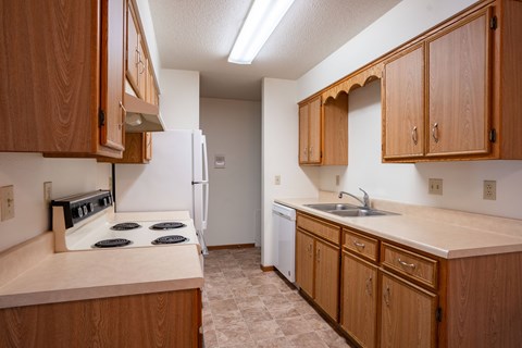 A kitchen with wooden cabinets and a white refrigerator.