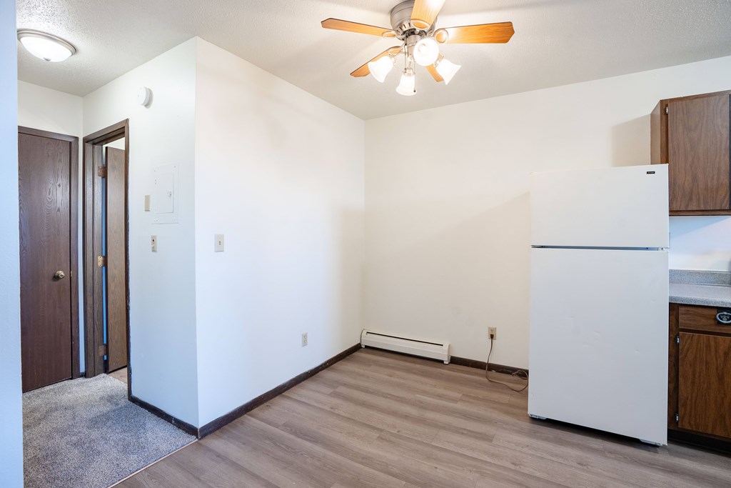 A kitchen with a white fridge and a ceiling fan. West Fargo, ND Parkwest Gardens