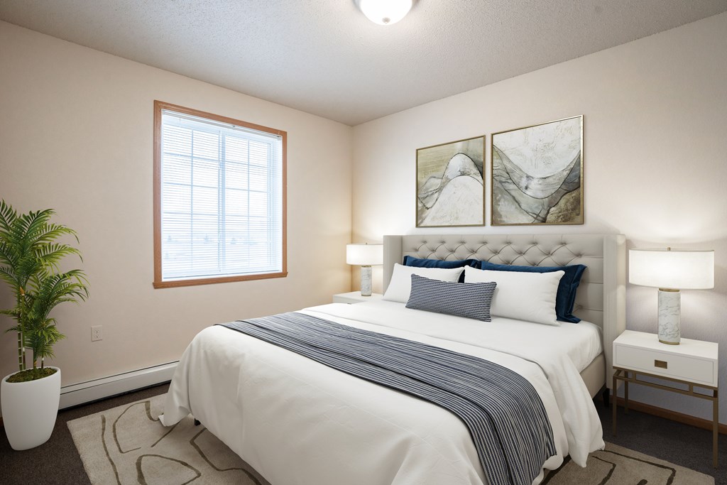 A bedroom with a large bed, a potted plant, and two framed pictures on the wall.
