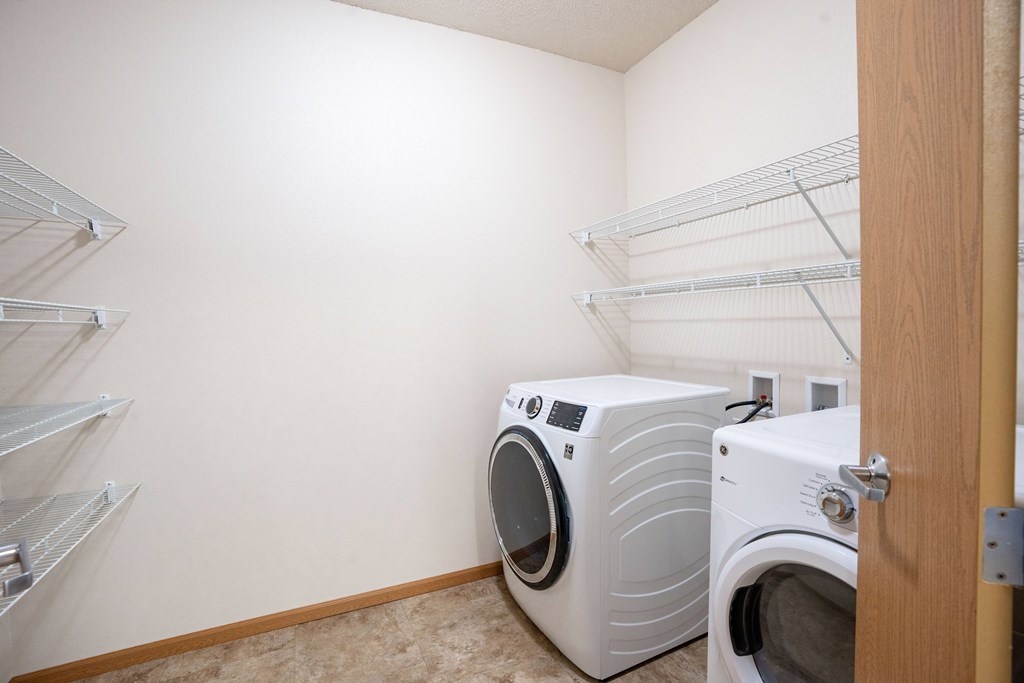 A laundry room with a washer and dryer. Fargo, ND North Sky II Apartments
