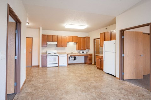 A kitchen with brown cabinets and a white refrigerator.
