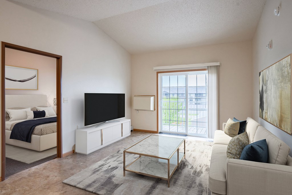 A living room with a white couch and a black television.