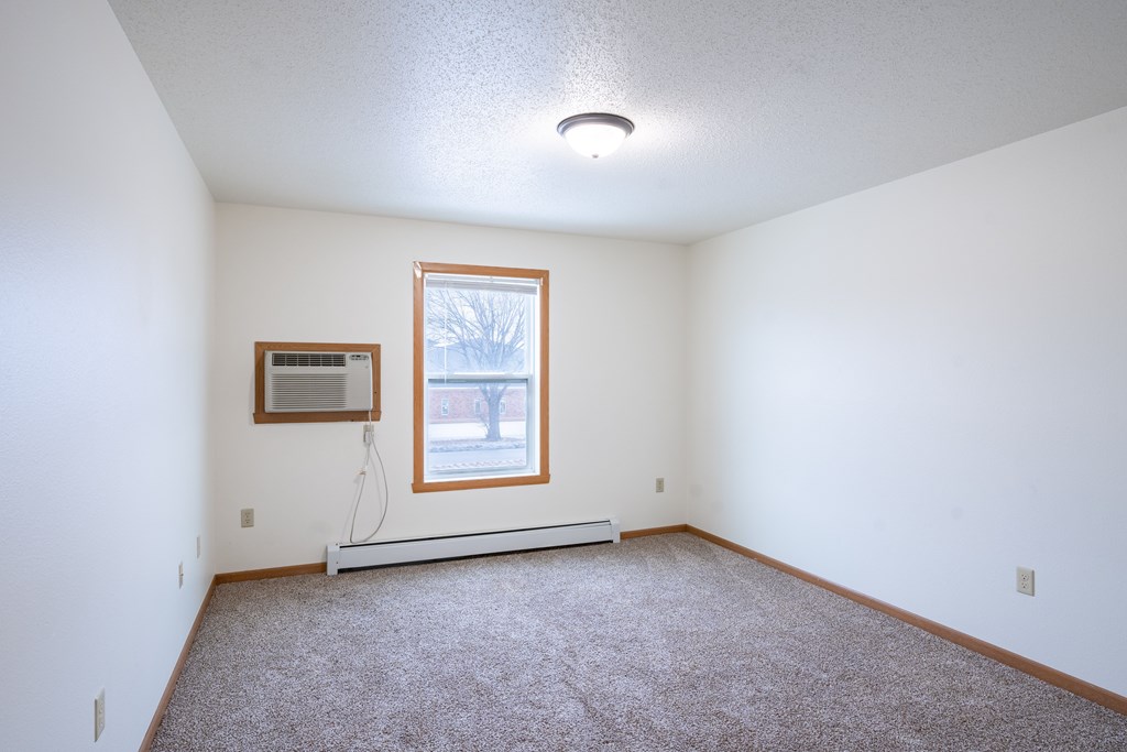 A room with a window and a picture on the wall. Fargo, ND Park Place Apartments
