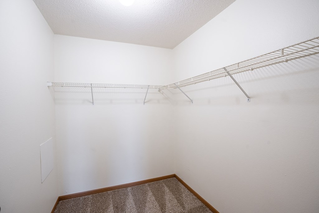 Empty room with a shelf and carpeted floor. Fargo, ND Park Place Apartments