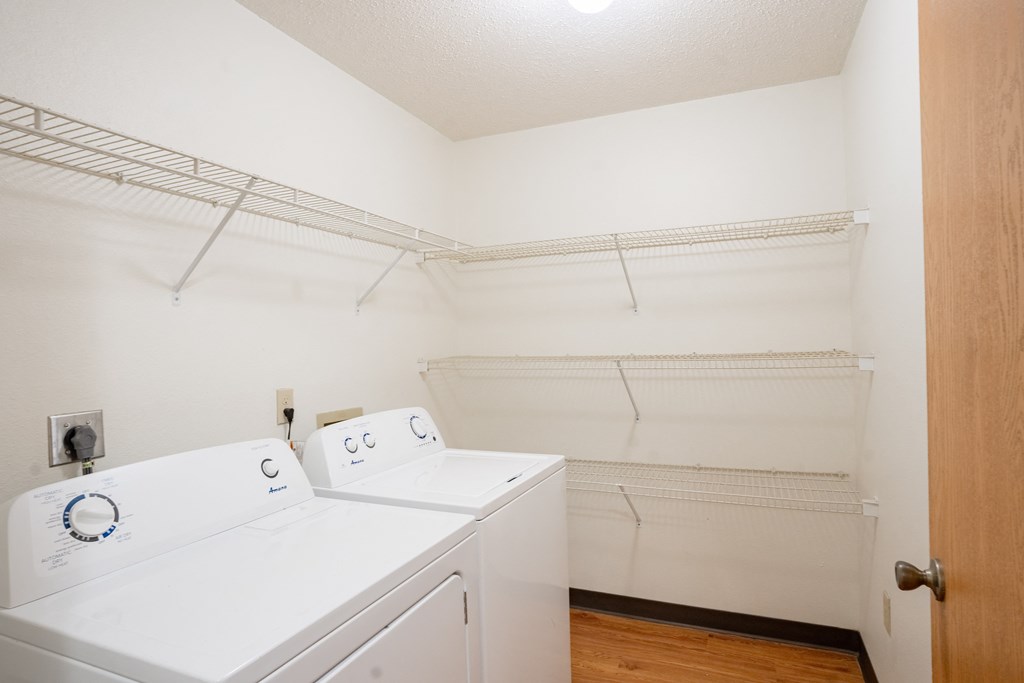 A laundry room with a washer and dryer. Fargo, ND Park Place Apartments