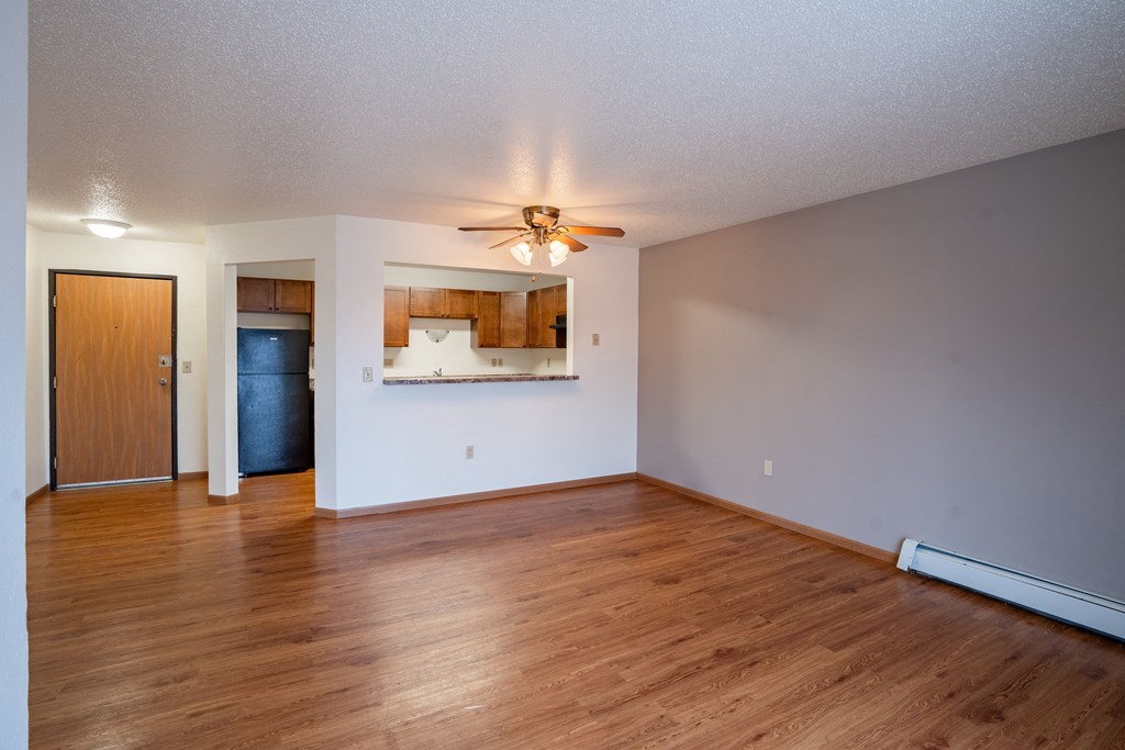 A room with a ceiling fan and wooden floors. Fargo, ND Park Place Apartments