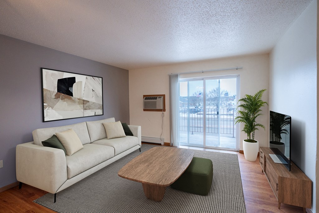 A living room with a white couch and a wooden coffee table. Fargo, ND Park Place Apartments