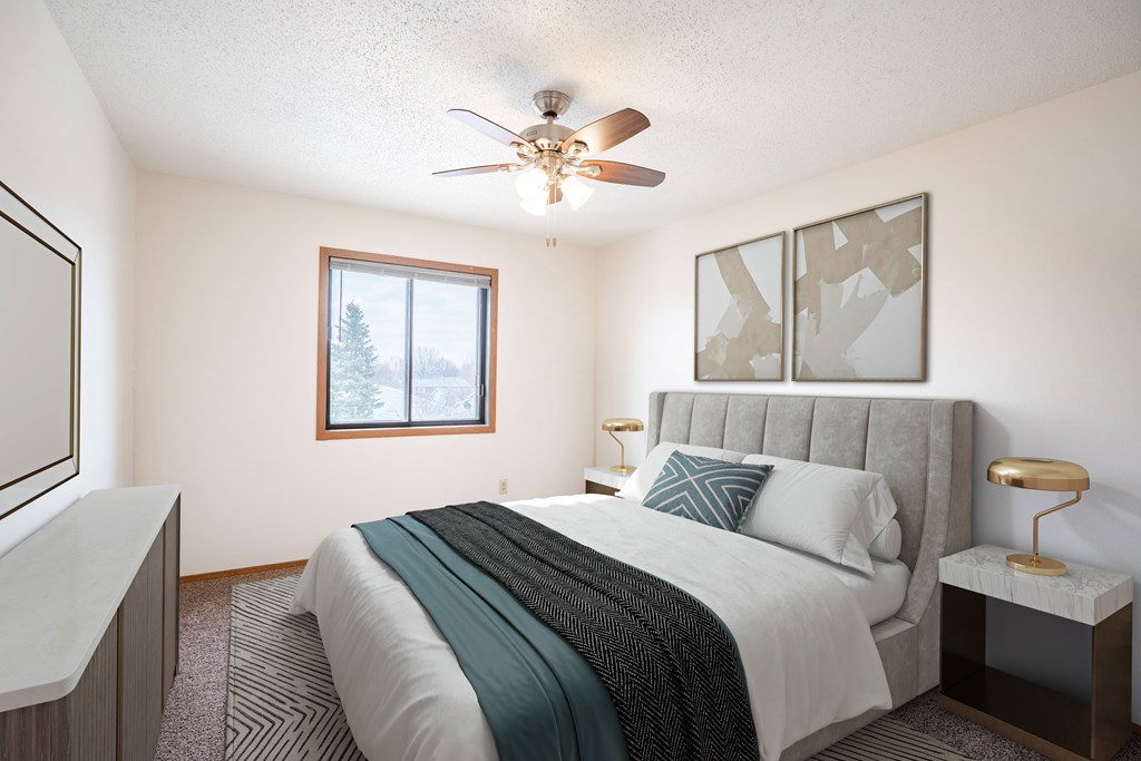 A bedroom with a bed, nightstand, and window. Fargo, ND Hawthorn Apartments