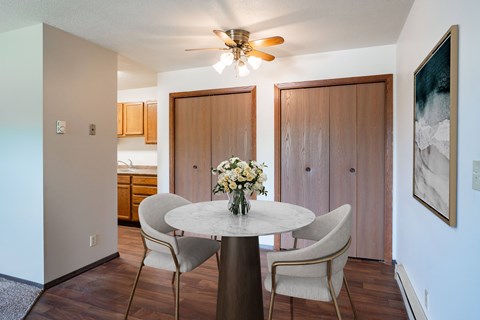 A dining room with a round table and chairs. Fargo, ND Summerfield Apartments