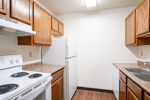 A kitchen with a white stove and a white refrigerator.