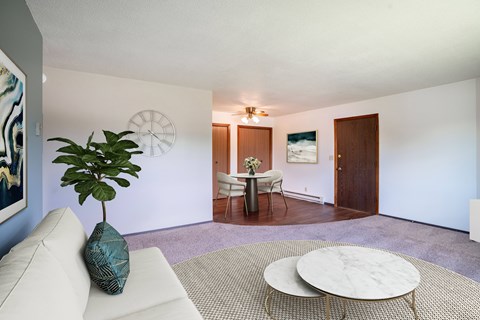 A living room with a white couch and a round coffee table.