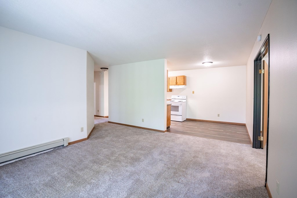 A room with a carpeted floor and a white wall. Grand Forks, ND Columbia West Apartments