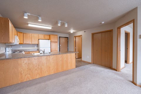 A kitchen with wooden cabinets and a countertop. Fargo, ND East Bridge Apartments
