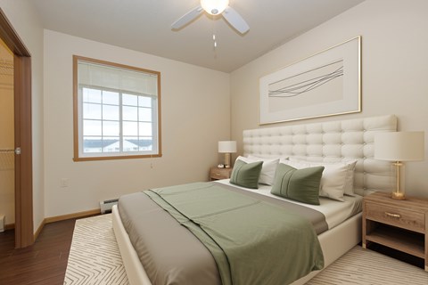 A bedroom with a large bed and a ceiling fan.