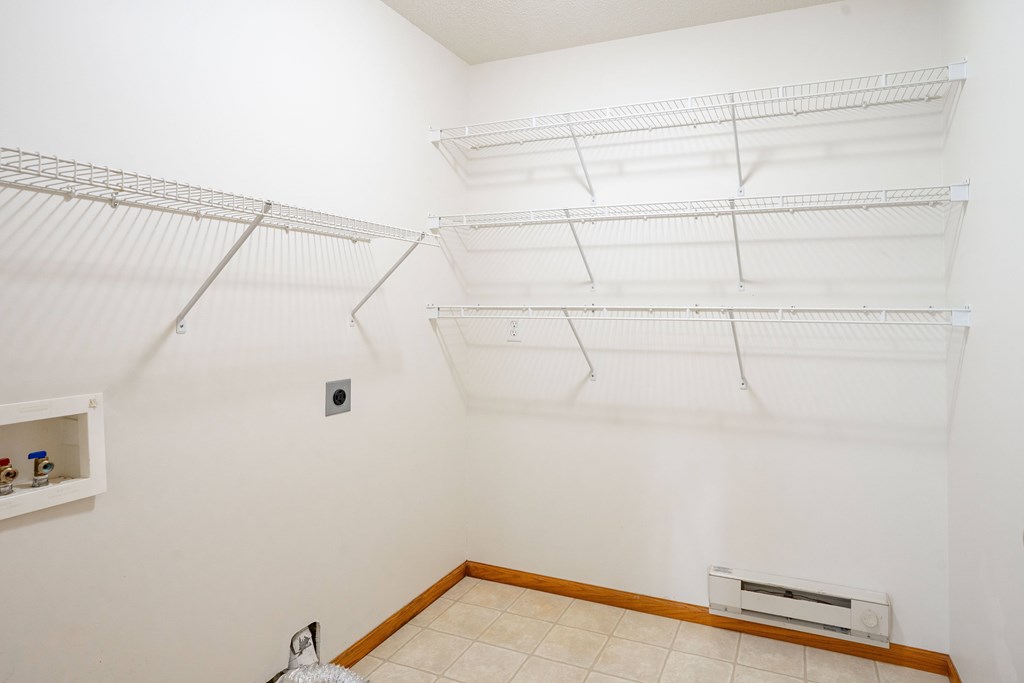 Empty white room with shelves and a radiator. Fargo, ND Crown Court 2 Apartments
