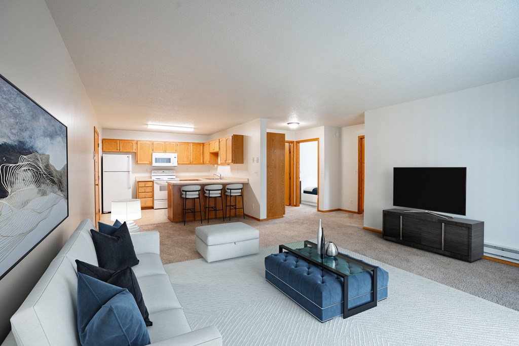 A modern living room with a white couch and a blue coffee table. Fargo, ND Crown Court Apartments