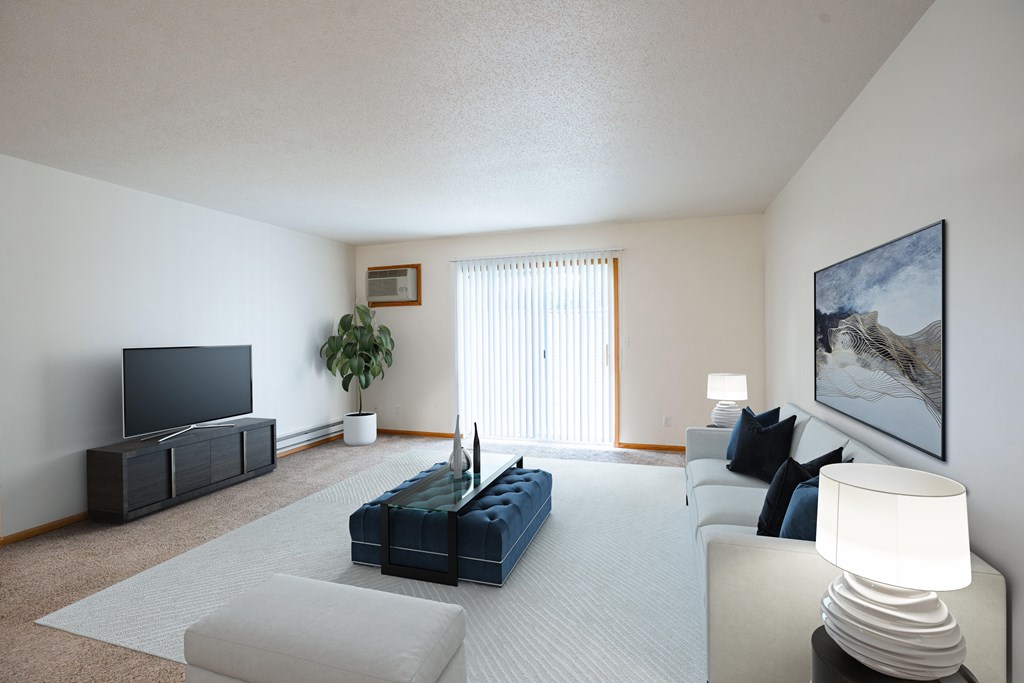 A living room with a blue couch and a television. Fargo, ND Crown Court Apartments
