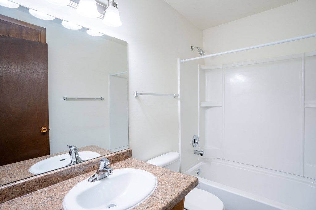 A bathroom with a toilet, sink, and bathtub. Fargo, ND Park Terrace Apartments