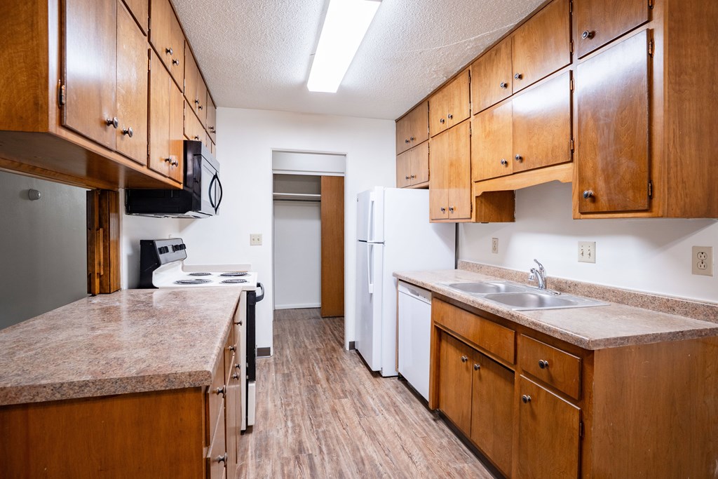 A kitchen with wooden cabinets and a granite counter top. Fargo, ND Park Terrace Apartments