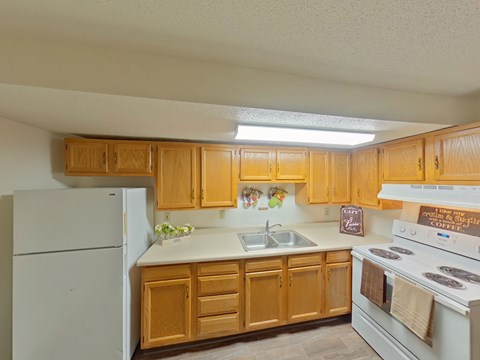 A kitchen with wooden cabinets and white appliances.