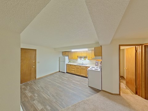 A kitchen with a white fridge and a white washing machine.