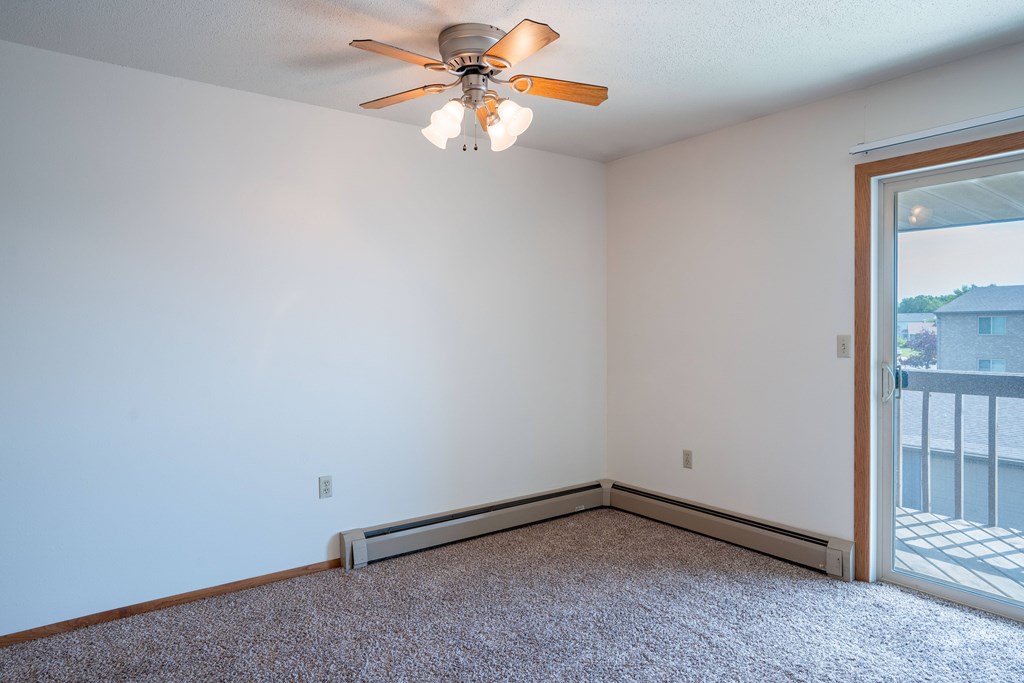 A room with a ceiling fan and a window. West Fargo, ND Clearview Apartments