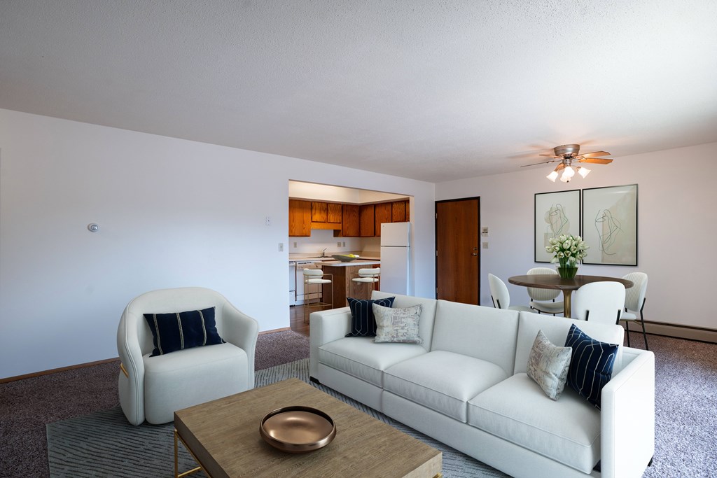 A living room with a white couch, a chair, and a coffee table. West Fargo, ND Clearview Apartments