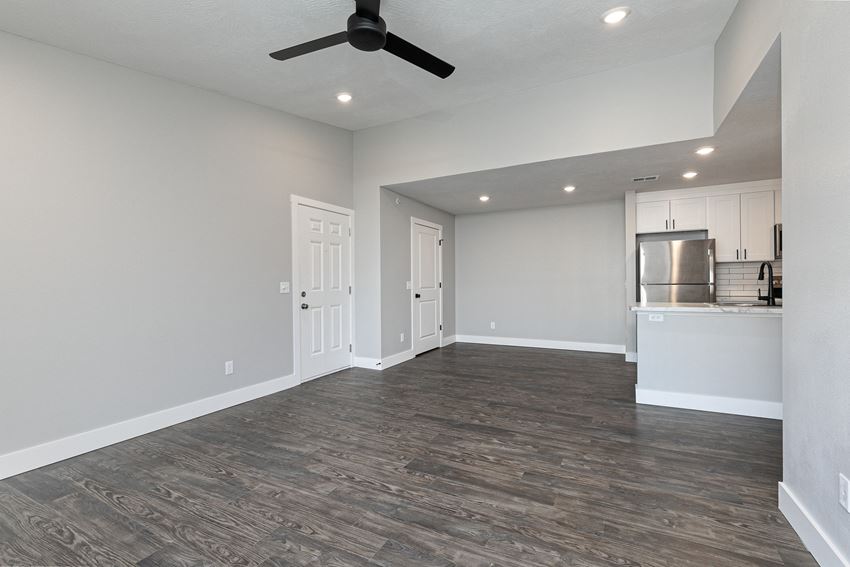 living room and kitchen with hardwood floors and ceiling fan at Quail Creek Apartments