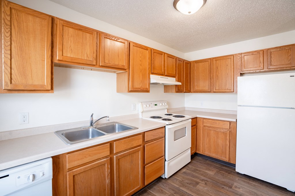 West Fargo, ND Sheyenne Terrace Townhomes | 415A | Kitchen A kitchen with wooden cabinets and white appliances. West Fargo, ND Sheyenne Terrace Townhomes