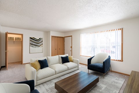 A living room with a white couch and a blue chair.