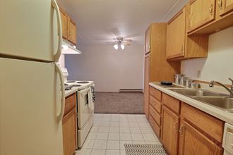 a kitchen with a stove refrigerator and sink. Fargo, ND Alden Pines Apartments