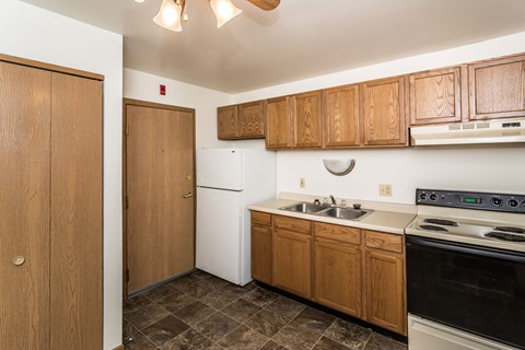 a kitchen with white appliances and wooden cabinets