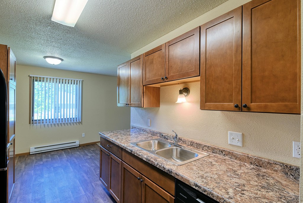 Grand Forks, ND Madison Apartments. A kitchen with a window in the dining area.