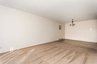 Grand Forks, ND Barrette Arms Apartments.  a living room with white walls and a beige carpet