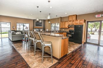 A kitchen with a black refrigerator and wooden cabinets.
