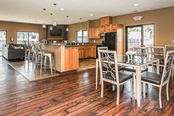 A kitchen with a bar area and chairs.