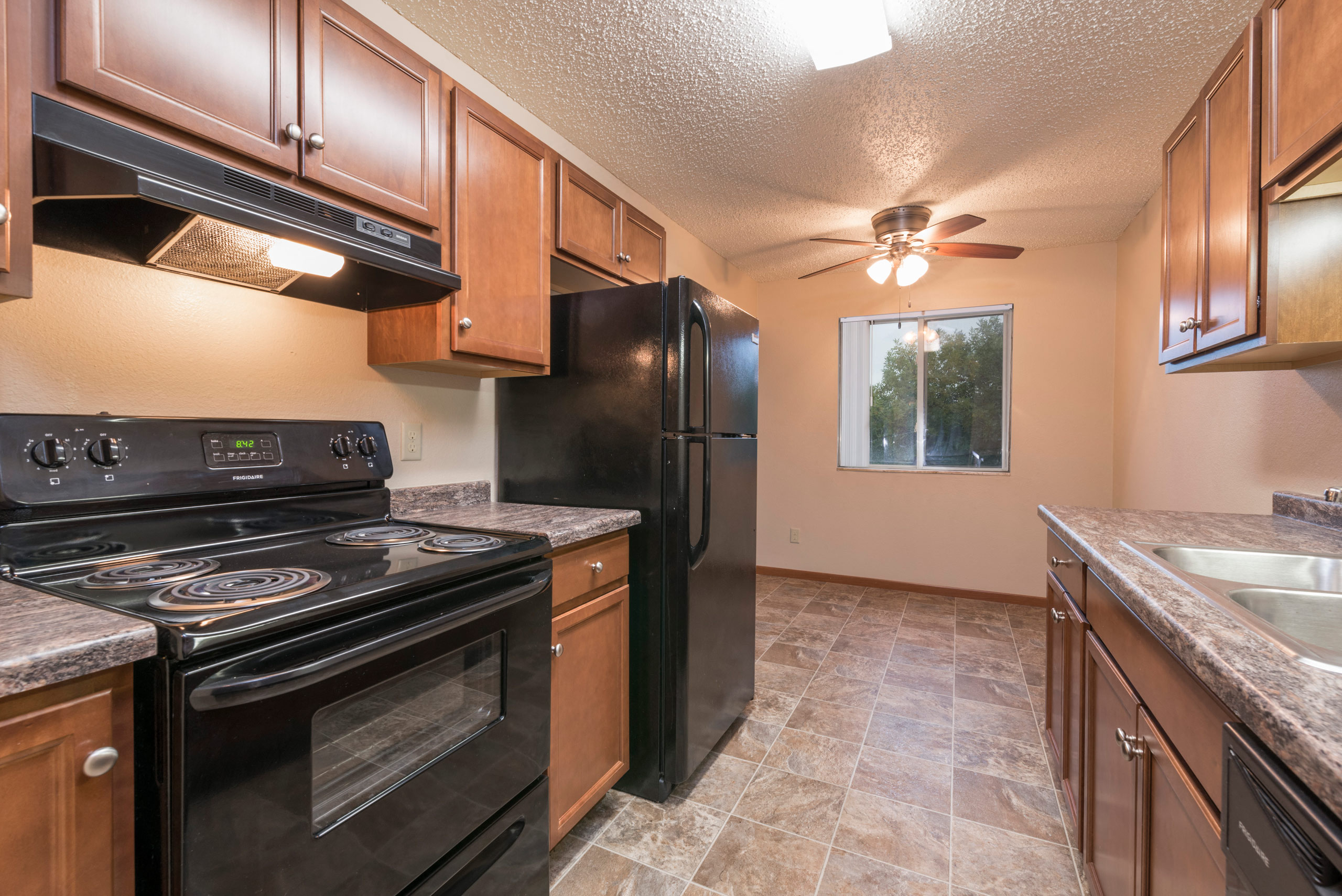a kitchen with black appliances and wooden cabinets