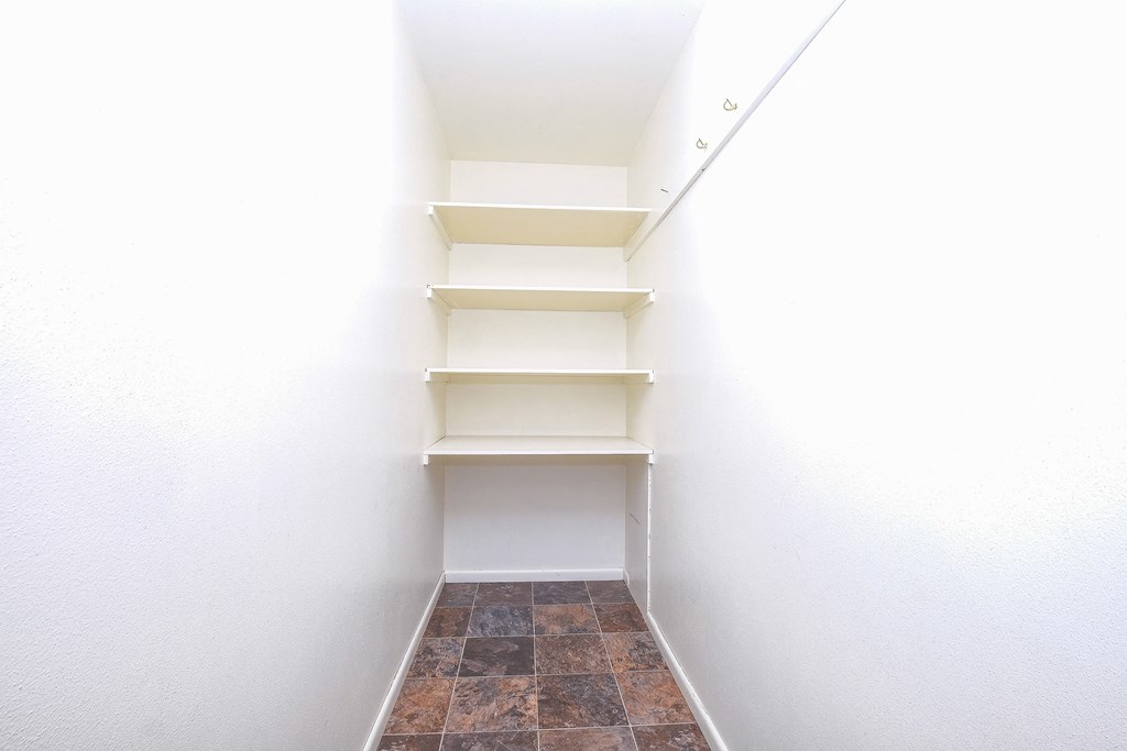 a walk in closet with shelves and a white wall. Fargo, ND Betty Ann Apartments