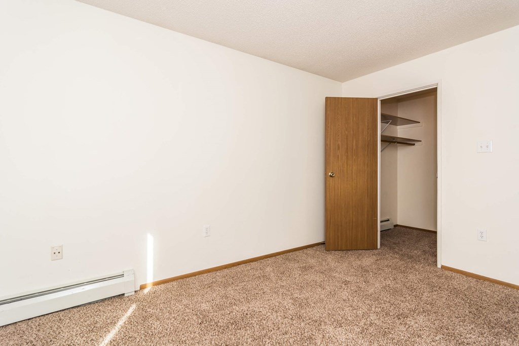 Grand Forks, ND Bristol Park Apartments. a bedroom with a closet and carpeted floor
