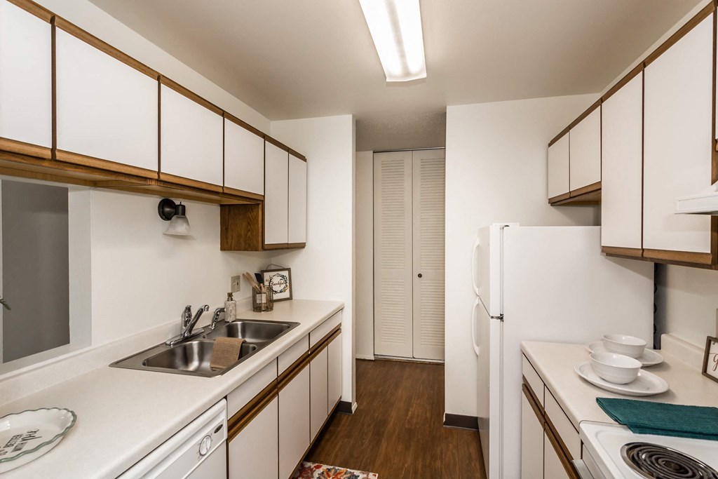 Grand Forks, ND Bristol Park Apartments | Kitchen Grand Forks, ND Bristol Park Apartments. A kitchen with white cabinets and appliances with wood floors