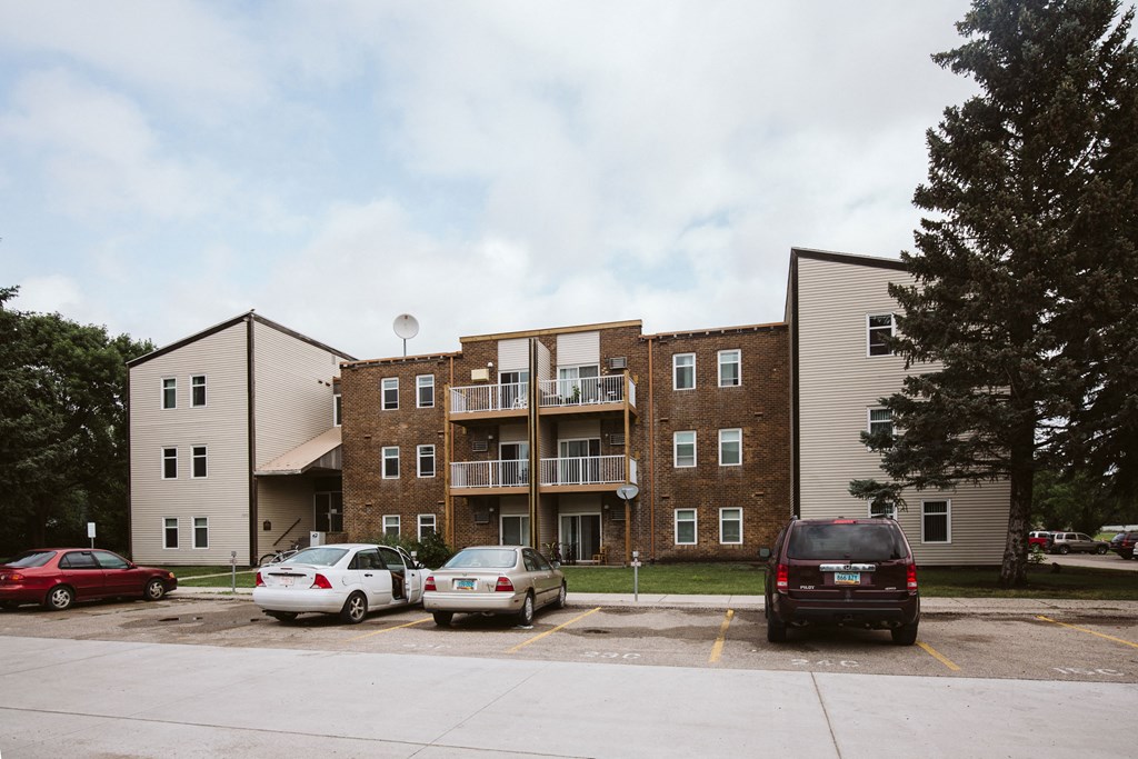 Grand Forks, ND Bristol Park Apartments | Exterior Grand Forks, ND Bristol Park Apartments. A brick apartment building with cars parked in front of it