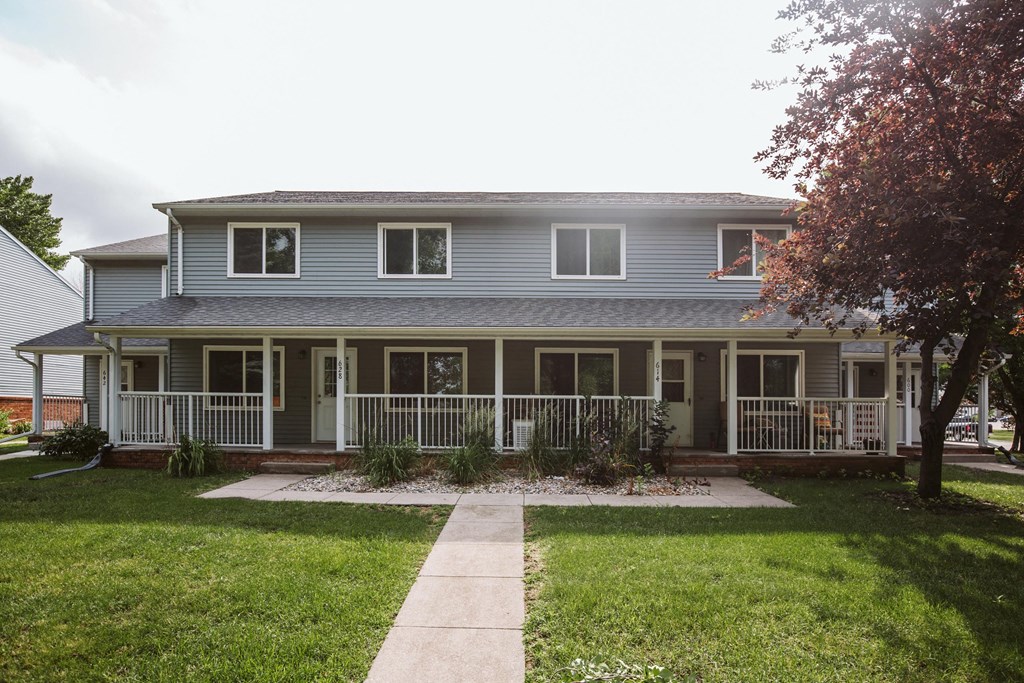 Grand Forks, ND Bristol Park Apartments.a house with a blue siding and a green lawn