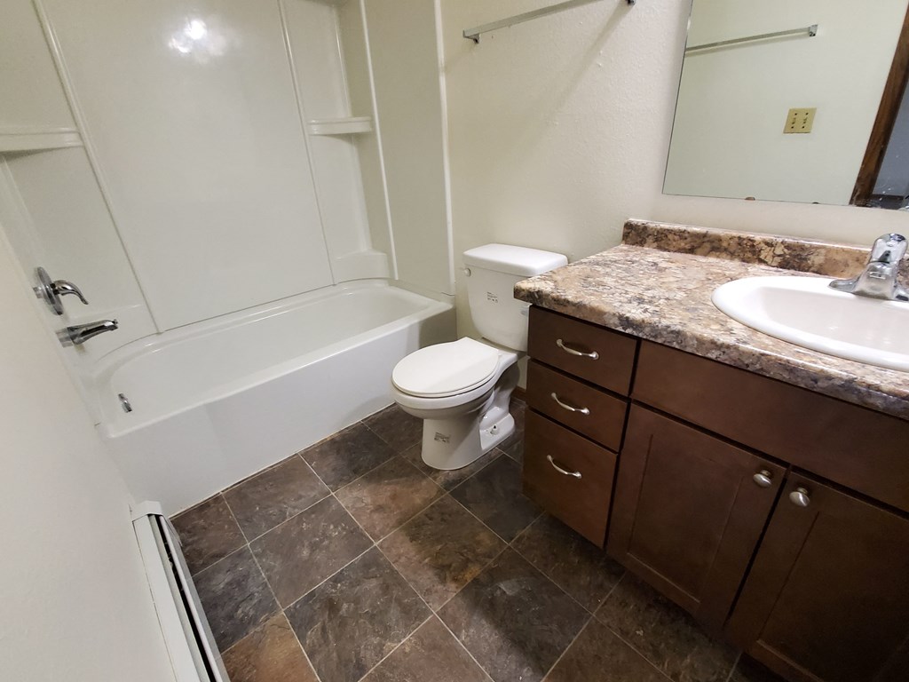 an empty bathroom with a sink toilet and bath tub. Fargo, ND Brookfield Apartments