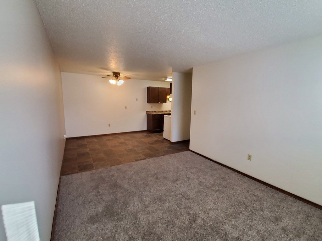 the living room and kitchen of an empty apartment.Fargo, ND Brookfield Apartments