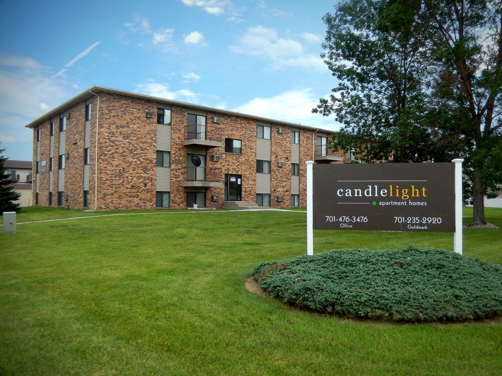 Fargo, ND Candlelight Apartments | Exterior a large brick building with a sign in front of it. Fargo, ND Candlelight Apartments