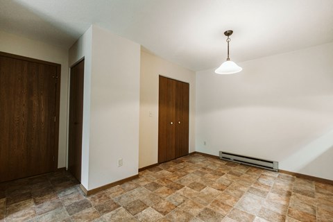 Grand Forks, ND Carling Manor Apartments. a dining room with white walls and a brown tile floor